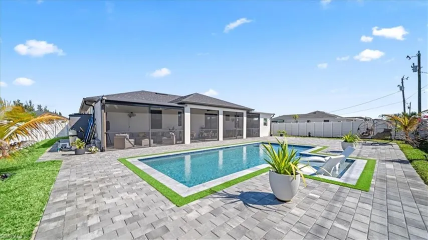 View of pool with a sunroom, patio surround, and a fenced backyard