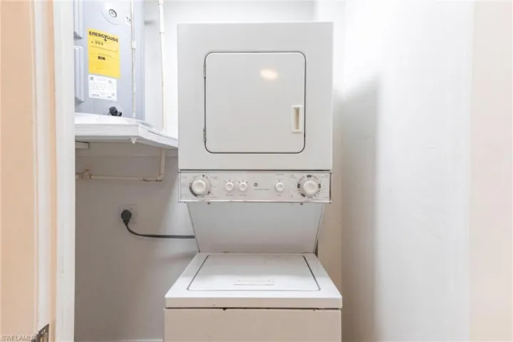 Washroom featuring stacked washer / drying machine