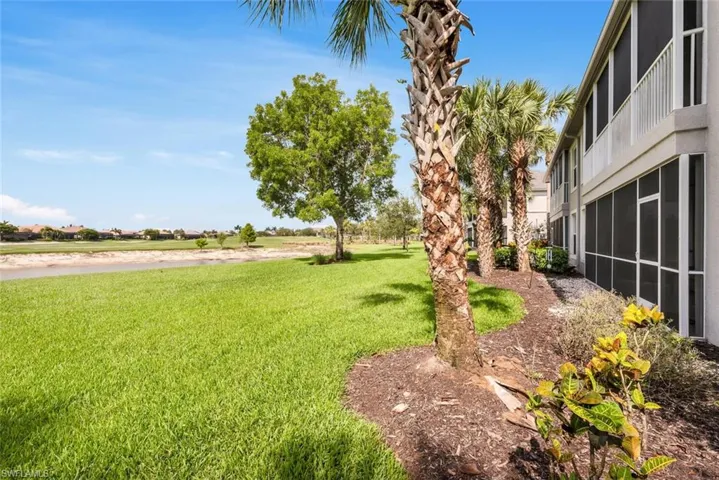 View of grassy yard featuring a sunroom