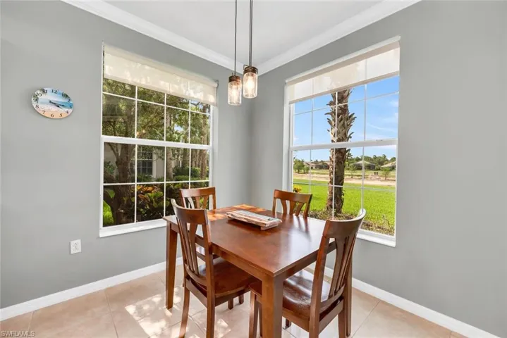 Dining area with crown molding and light tile patterned floors
