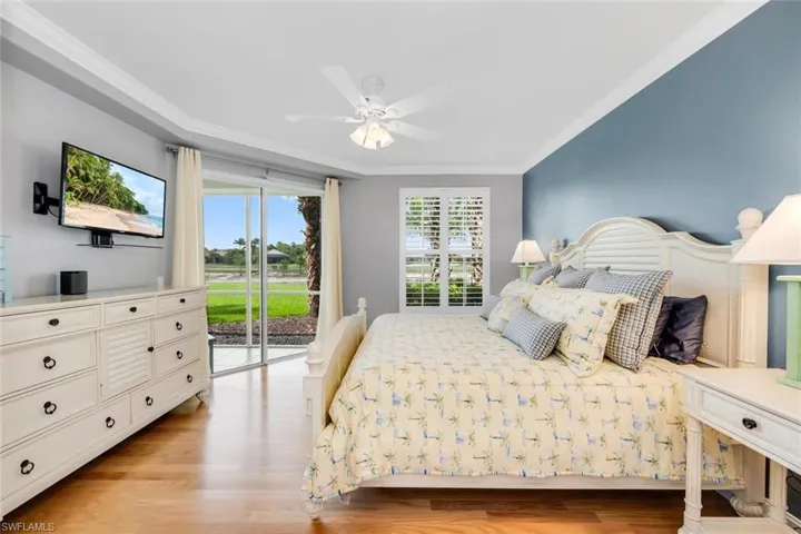 Bedroom featuring ornamental molding, light wood-style floors, access to exterior, and ceiling fan