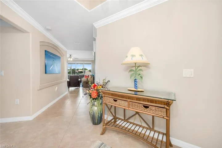 Hallway featuring ornamental molding and light tile patterned floors