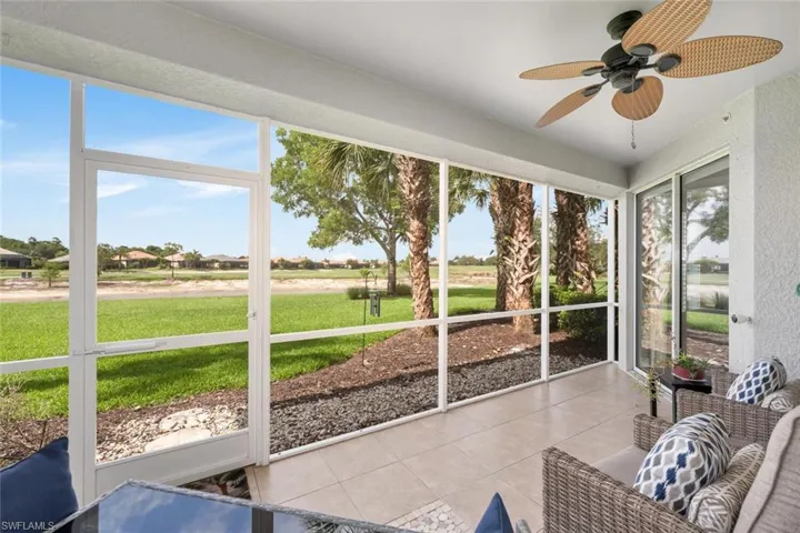 Sunroom / solarium with a ceiling fan and a residential view