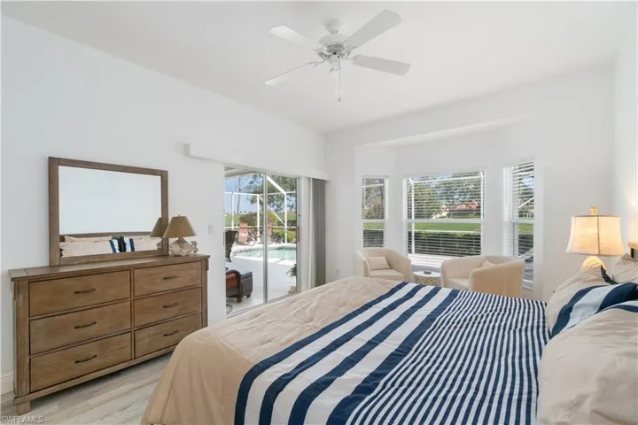 Bedroom with ceiling fan, light wood-type flooring, and access to outside