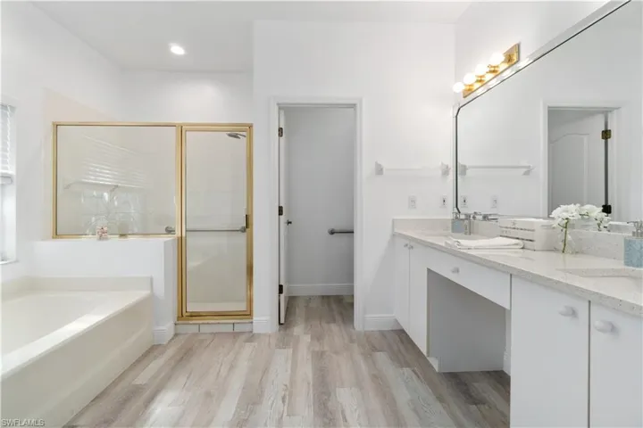 Bathroom with tile / wood-style flooring, vanity, and shower with separate bathtub