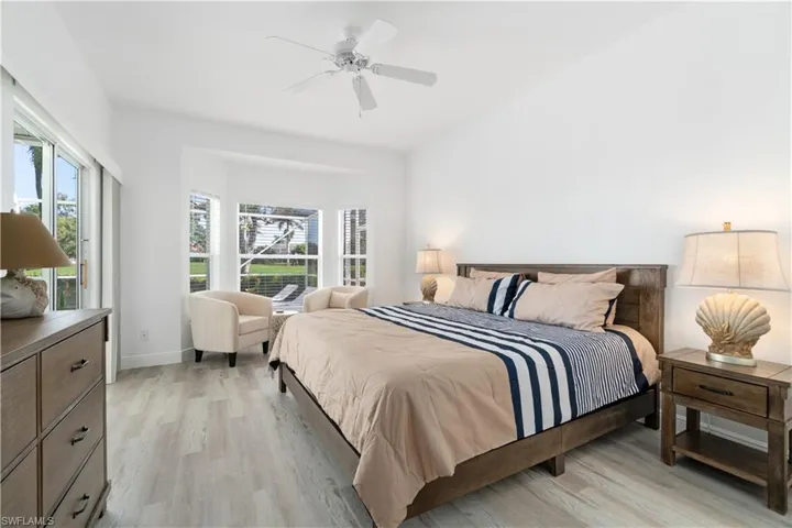 Bedroom featuring multiple windows, ceiling fan, and light hardwood / wood-style floors