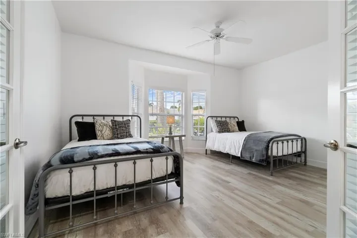 Bedroom with wood-type flooring, french doors, and ceiling fan