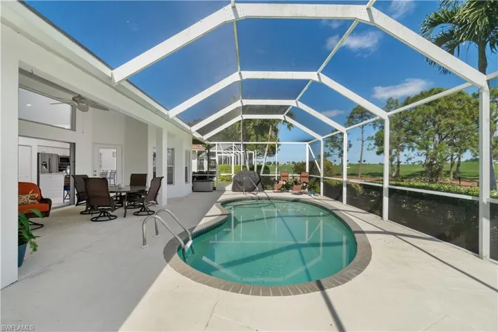 View of pool featuring a water view, ceiling fan, a patio, and screen enclosure