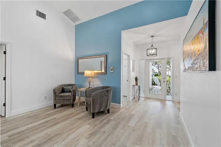 Foyer entrance with an inviting chandelier and light wood-type flooring