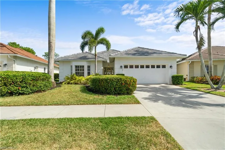 Ranch-style home with a garage and a front lawn