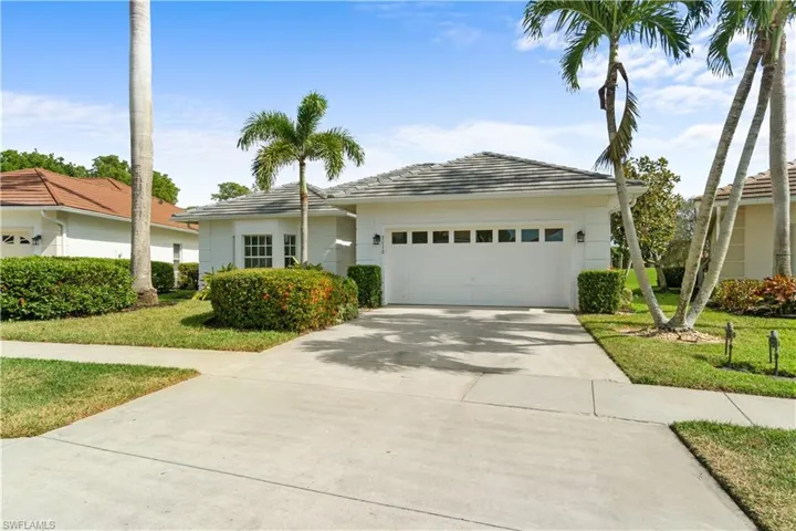 View of front of property with a garage and a front lawn