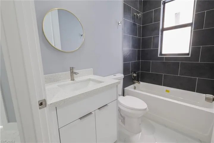 Bathroom featuring vanity and washtub / shower combination