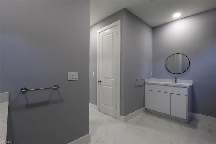 Bathroom with vanity and light marble finish floors