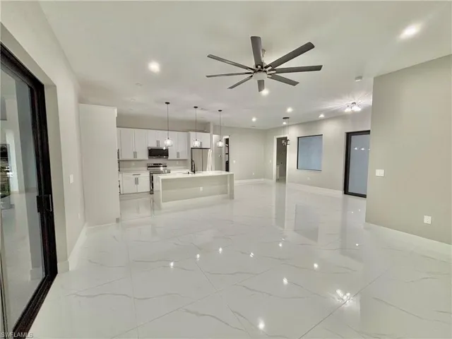 Unfurnished living room with light marble finish floors, recessed lighting, and ceiling fan