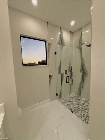 Full bathroom featuring a marble finish shower, vanity, recessed lighting, and tile patterned flooring