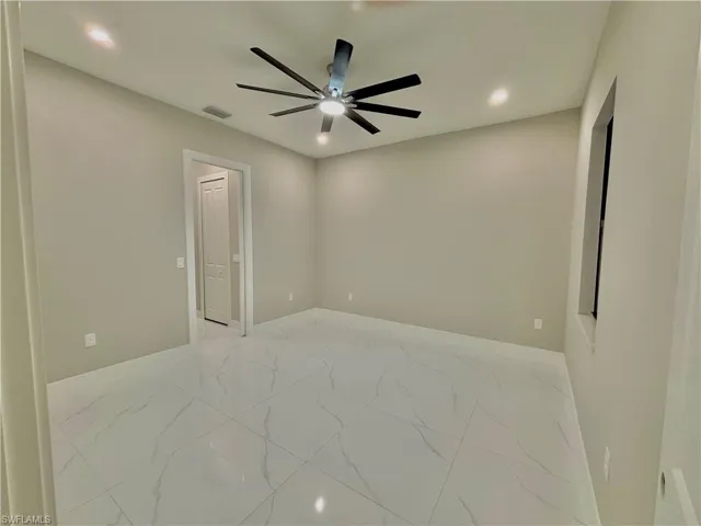 Empty room featuring light marble finish flooring, recessed lighting, and a ceiling fan