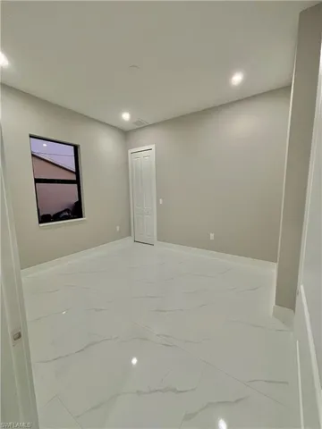 Unfurnished room with light marble finish floors and recessed lighting