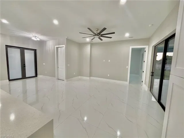 Spare room featuring french doors, recessed lighting, and light marble finish flooring