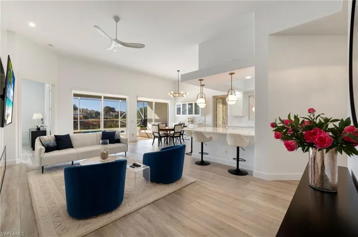 Living room featuring recessed lighting, ceiling fan, a chandelier, and light wood-style flooring