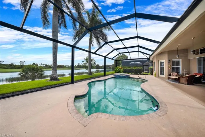 View of pool featuring glass enclosure, a water view, ceiling fan, an in ground hot tub, and a patio area