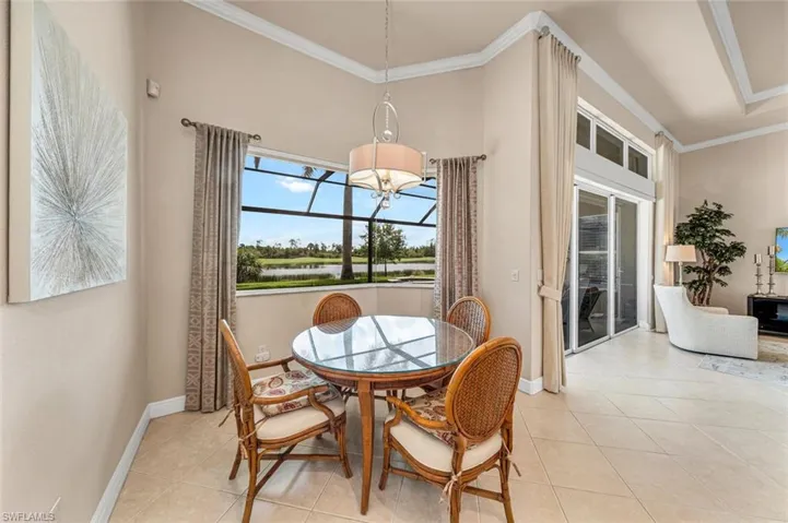 Dining room featuring light tile patterned floors, crown molding, a towering ceiling, and a chandelier