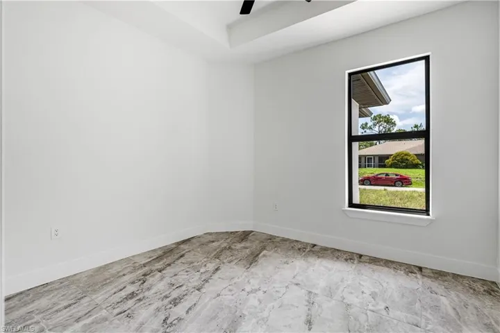 Tiled empty room featuring ceiling fan