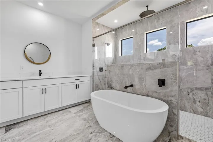 Bathroom featuring tile patterned flooring, a healthy amount of sunlight, and tile walls