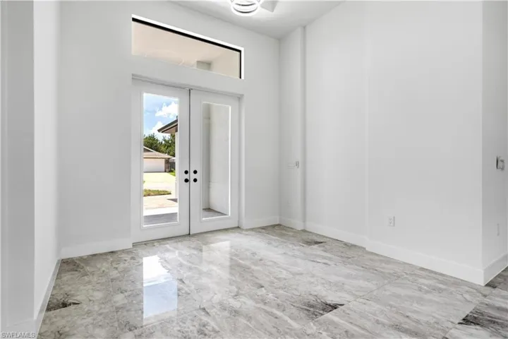 Entryway with light tile patterned flooring and french doors