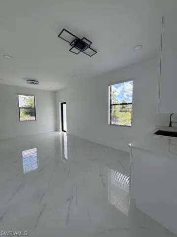 Unfurnished dining area with healthy amount of natural light, light marble finish flooring, and recessed lighting