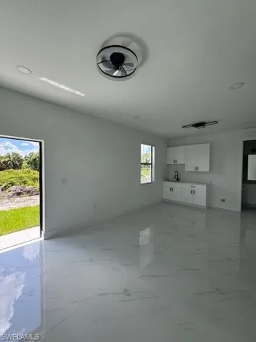Unfurnished living room featuring light marble finish floors