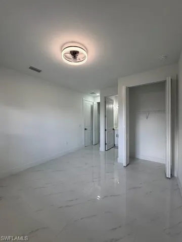 Master Primary unfurnished bedroom with a closet and light marble finish flooring and bathroom.