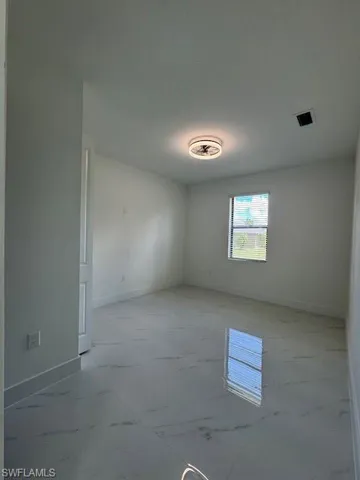 Empty room with baseboards and light marble finish floors