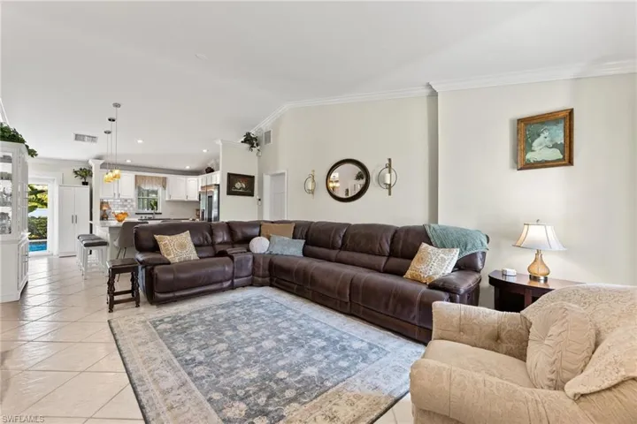 Living room with ornamental molding and light tile flooring