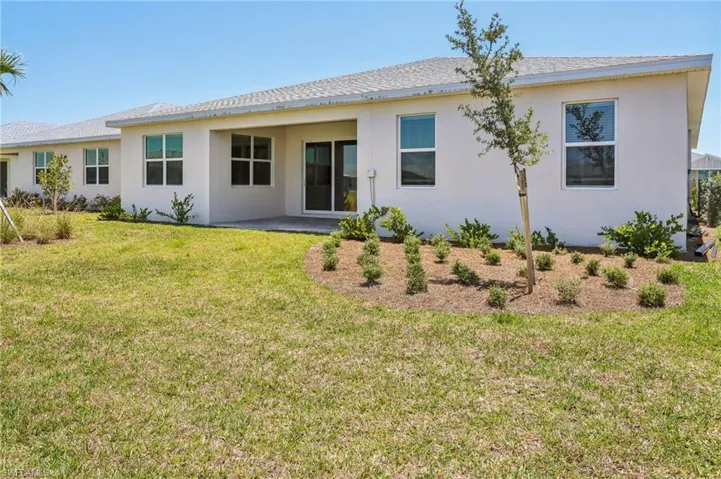 Rear view of house with a yard and stucco siding