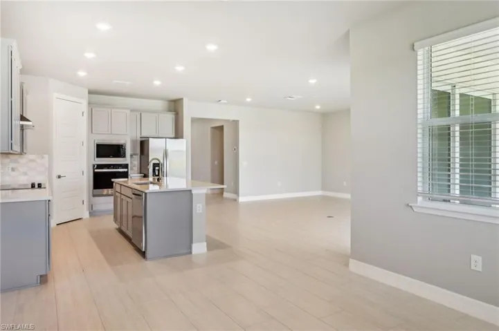 Kitchen featuring appliances with stainless steel finishes, healthy amount of natural light, tasteful backsplash, light countertops, and recessed lighting