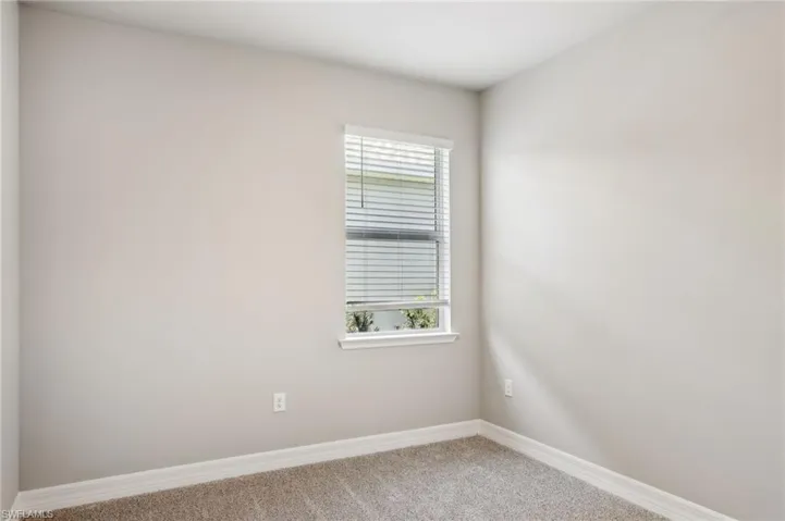 Empty room featuring carpet and baseboards