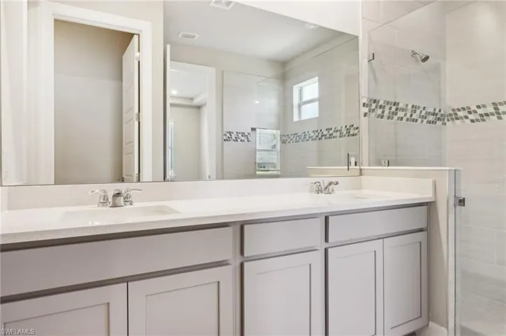 Full bathroom featuring a stall shower and double vanity