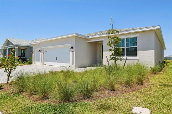 Single story home featuring stucco siding, driveway, and a garage