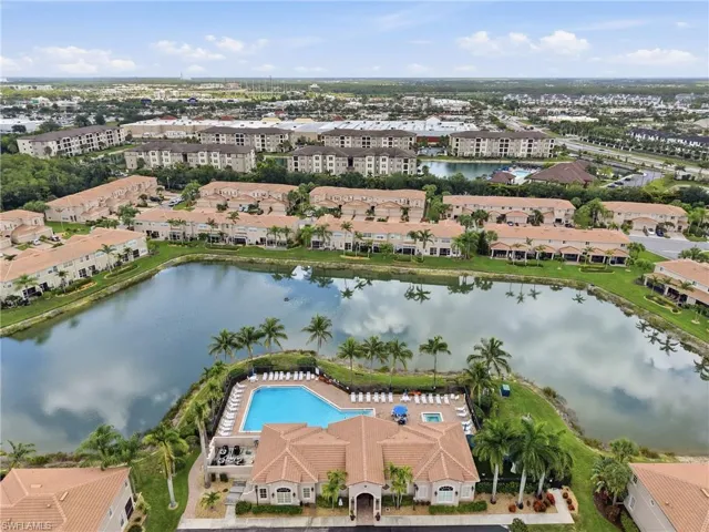 Community featuring a central lake, expansive outdoor pool, and multiple residential buildings
