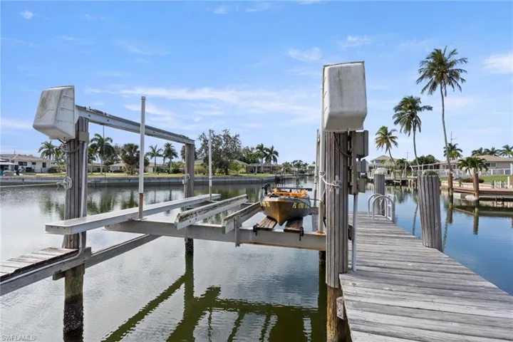 Dock area featuring boat lift and a water view