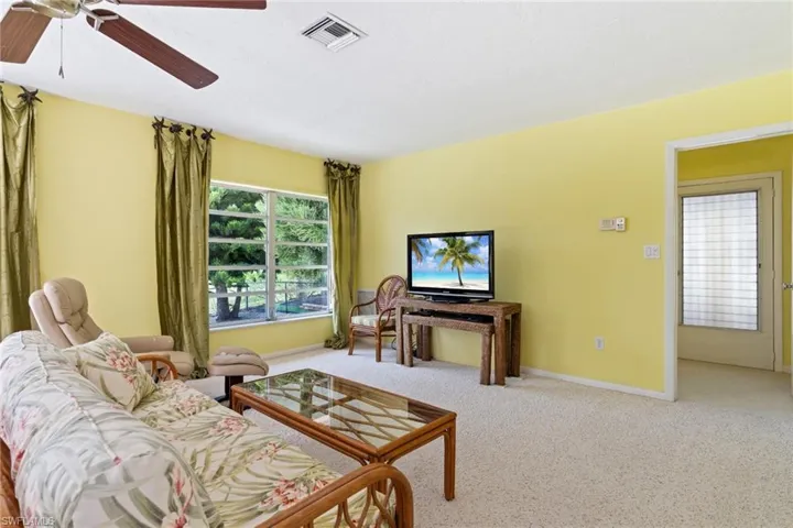 Carpeted living room with baseboards and a ceiling fan