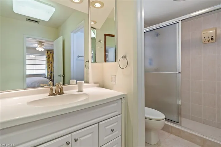 Bathroom with vanity, a stall shower, connected bathroom, and light tile patterned floors