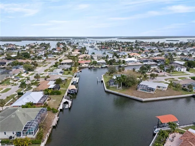 Aerial view of property and surrounding area featuring a nearby body of water and nearby suburban area