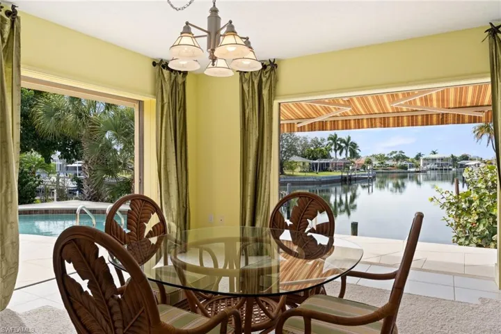 Tiled dining space featuring a water view and a chandelier