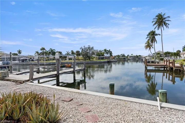 Dock featuring boat lift, a water view, and a residential view