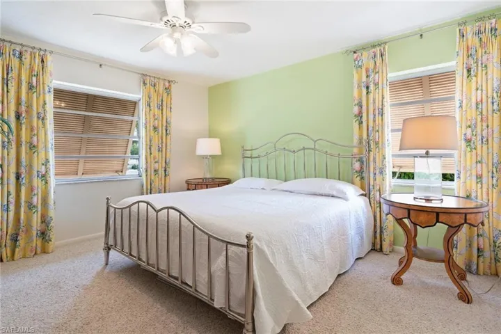 Carpeted bedroom featuring a ceiling fan and baseboards
