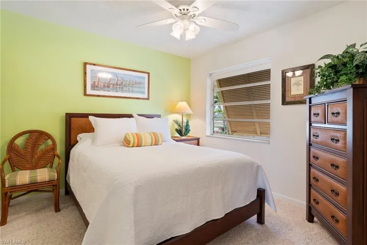 Bedroom with ceiling fan and light colored carpet