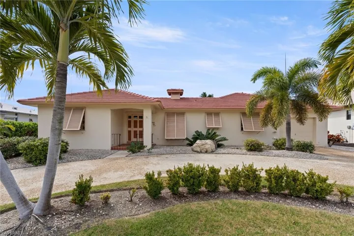 Ranch-style home featuring a tile roof, a chimney, stucco siding, and a garage
