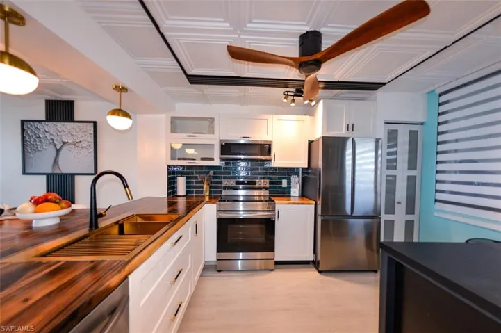 ACACIA BUTCHER  BLOCK COUNTERTOPS.  FULL HEIGHT TILED BACKSPLASH.  VERTICAL LIFT UPPER CABINETS.  GLASS-PANEL PANTRY DOOR.  CUSTOM ZEBRA BLINDS.  PVC CEILING TILE W/DECORATE WOOD PANEL ACCENTS.  LIGHT FIXTURES.