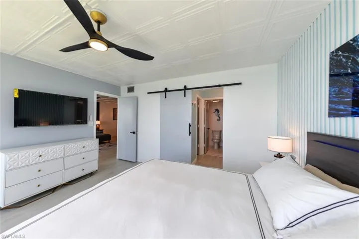 OWNER'S SUITE SHOWING ENTRANCE TO EN-SUITE BATH AND WALK-IN CLOSET.  WALL-MOUNTED FLAT SCREEN TV.